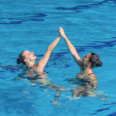 Fließende Anmut und synchronisierte Schönheit eines weiblichen Duetts, das in perfekter Harmonie im faszinierenden Wasserballett tanzt. 