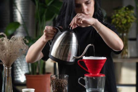 Téléchargez les photos : Femme barista faire du café goutte à goutte, verser de l'eau chaude sur le marc de café - en image libre de droit
