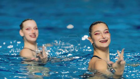 Téléchargez les photos : La natation synchronisée en duo dynamique apporte de l'art fluide à la piscine, des mouvements gracieux et une précision synchronisée captivent dans une danse aquatique envoûtante - en image libre de droit