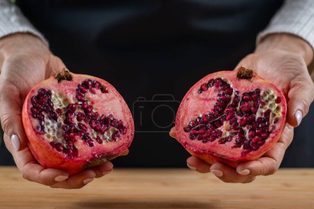 Photo for Woman holding Vibrant allure of pomegranate, a superfood packed with vitamin C, Vitamin K, potassium, folic acid, dietary fibers, and flavonoids. - Royalty Free Image