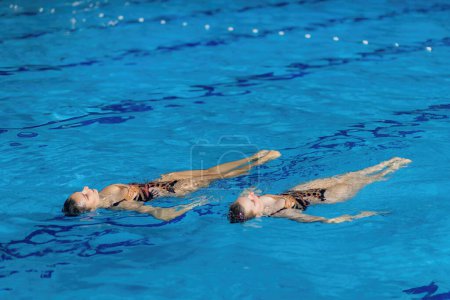 Foto de Dúo de natación sincronizado baila con gracia a través del agua, mostrando coordinación y coreografía acuática encantadora - Imagen libre de derechos