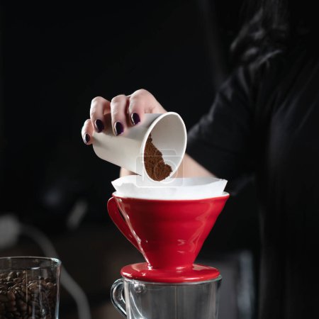 Foto de Mano de barista hembra calificada vierte café a tierra en un gotero de café de cerámica - Imagen libre de derechos