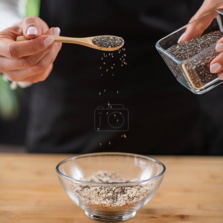 Nutritious breakfast by woman incorporating chia seeds into your oatmeal, a delightful and healthy meal.