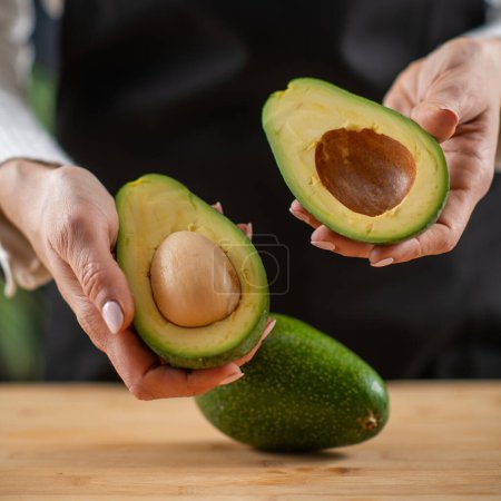 woman holding Fresh, organic avocado, a superfood rich in monosaturated fat, vitamins, minerals, fibers, and phytonutrients