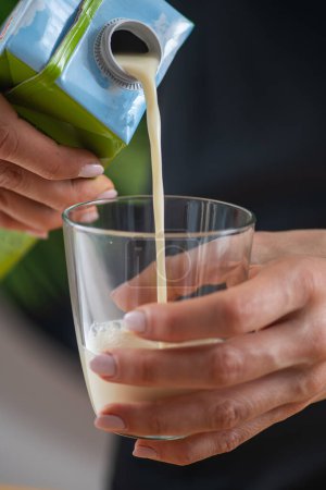 Healthy meal concept. woman pouring  soy milk in a glass