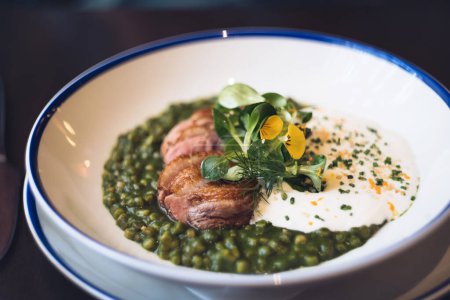 Duck breast with fregula pesto pasta, herbs and parmesan cheese foam