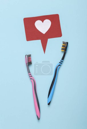 Love concept. Two toothbrushes with like icon on blue background