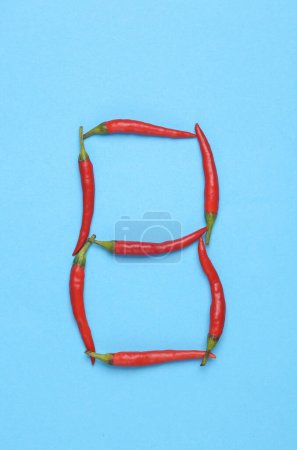Téléchargez les photos : Lettre B à base de piments rouges sur fond bleu - en image libre de droit