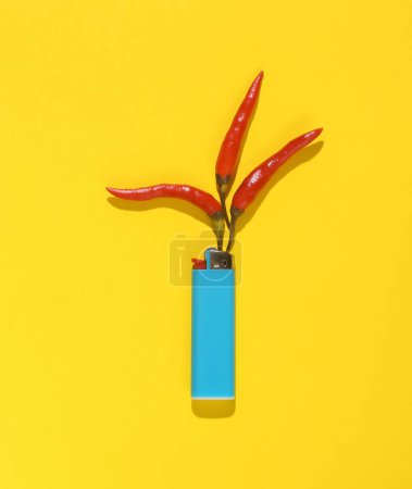 Lighter with red chili pepper in the shape of flame on yellow background. Creative idea