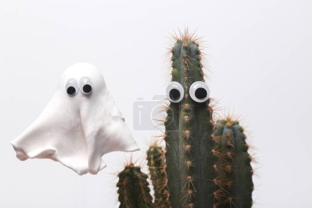 Stillleben zu Halloween. Kaktus mit Brille und Geist isoliert auf weißem Hintergrund