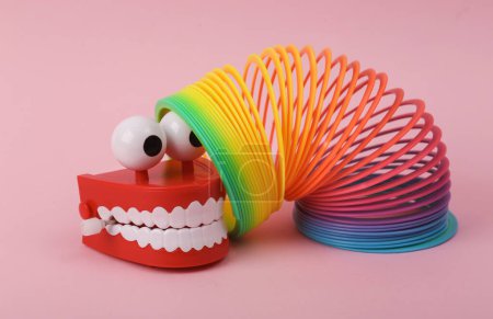Photo for Funny toy clockwork jumping teeth with eyes and spiral rainbow toy - Royalty Free Image