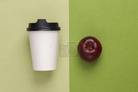 Foto de Mockup Blank Take Away Coffee Cup with apple on green background - Imagen libre de derechos