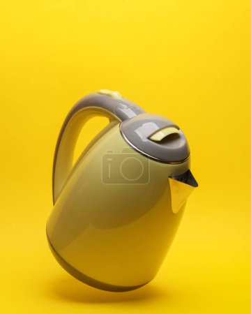 Téléchargez les photos : Bouilloire électrique lévite sur fond jaune avec ombre - en image libre de droit