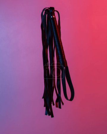 Photo for Sex shop leather whip floating in the air, isolated in blue-red neon gradient light. Levitating objects. Minimal concept - Royalty Free Image