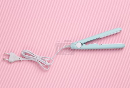 Photo for Mini hair straightener on pink background. Top view - Royalty Free Image