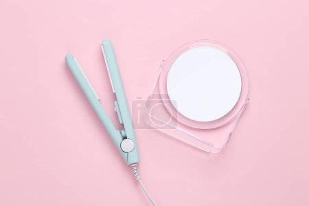 Photo for Hair straightener with mirror on a pink background - Royalty Free Image