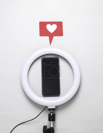 Lámpara de anillo led con smartphone e icono similar sobre un fondo gris. Equipo para bloguear y vlogging. Vista superior