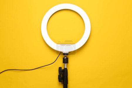 Lámpara de anillo led sobre fondo amarillo. Equipo para bloguear y vlogging. Vista superior