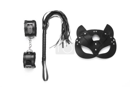 Photo for Leather handcuffs and whip with mask from sex shop on white background. Top view. Flat lay - Royalty Free Image