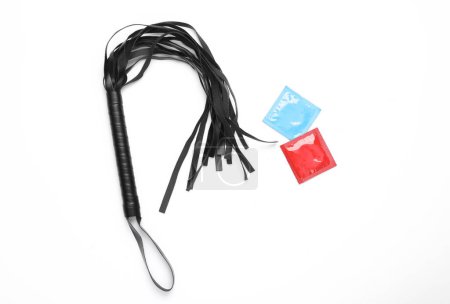 Photo for Leather whip from sex shop with condom pack on white background. Sex games. Top view. Flat lay - Royalty Free Image