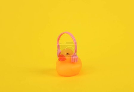 Foto de Pato de goma con auriculares sobre fondo amarillo. Concepto musical - Imagen libre de derechos