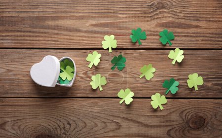 Photo for Heart shaped box with clover leaves on wooden background. Top view, flat lay - Royalty Free Image