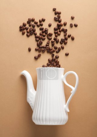 Téléchargez les photos : Théière en céramique avec grains de café sur fond brun. Vue du dessus - en image libre de droit