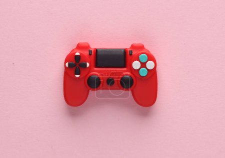 Photo for Red toy miniature gamepad on a pink background. Top view - Royalty Free Image