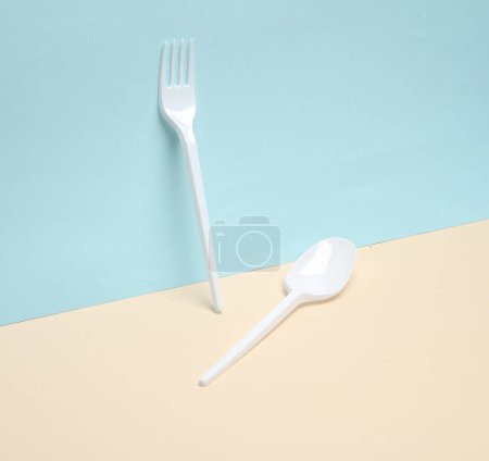Foto de Tenedor de plástico y cuchara sobre un fondo azul-amarillo. Diseño creativo - Imagen libre de derechos