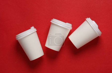 Photo for Mockup of white disposable cups with lids for hot drinks on red background - Royalty Free Image