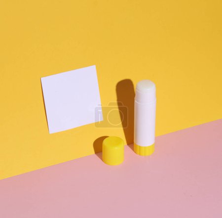 Tube of glue with a memo paper on a colored background. Announcement