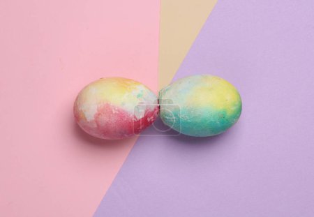 Zwei bunte Eier auf pastellfarbenem Hintergrund. Osterbräuche