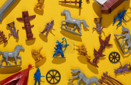 Foto de Conjunto de soldados y figuras del tema del salvaje oeste. Vaqueros e indios americanos. Diseño creativo, fondo amarillo - Imagen libre de derechos