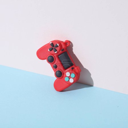 Rote Gamepad-Miniatur auf Pastell-Hintergrund. Kreative Gestaltung