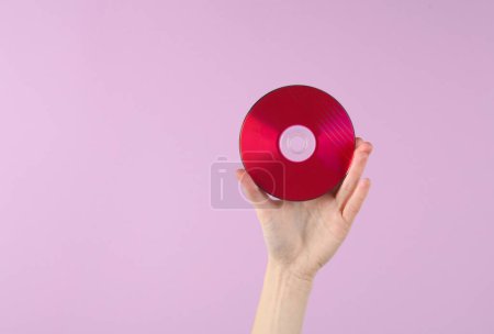 Photo for Hand holding cd disk on magenta background - Royalty Free Image