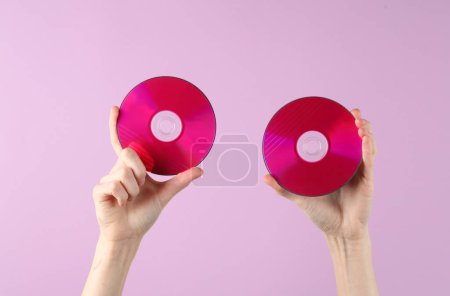 Photo for Hands holding cd disks on magenta background - Royalty Free Image