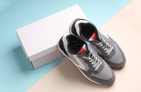 Foto de Nuevos zapatos de running grises con caja sobre fondo pastel. Zapatillas de deporte casual. - Imagen libre de derechos