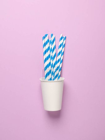 Photo for White cardboard cup with straws on a pink background. Party, birthday accessories - Royalty Free Image