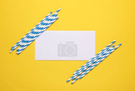 Photo for Blue paper straws with blank paper banner on a yellow background. Party, birthday concept - Royalty Free Image