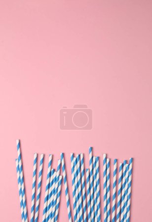 Photo for Blue paper straws on pink pastel background. Party, birthday accessories - Royalty Free Image