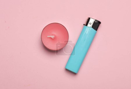 Aroma tea candle with lighter on a pink pastel background. Top view