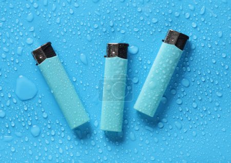 Lighters on a blue background with water drops.
