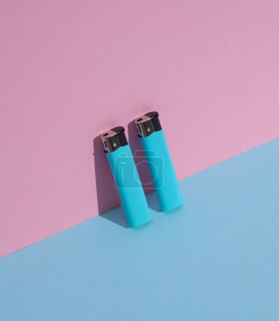 Encendedores sobre fondo azul-rosado. Composición minimalista. Diseño creativo