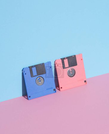 Téléchargez les photos : Disques disquettes roses et bleues sur fond pastel. Rétro années 80. Une technologie obsolète. Mise en page créative, minimalisme, nature morte minimale à la mode - en image libre de droit