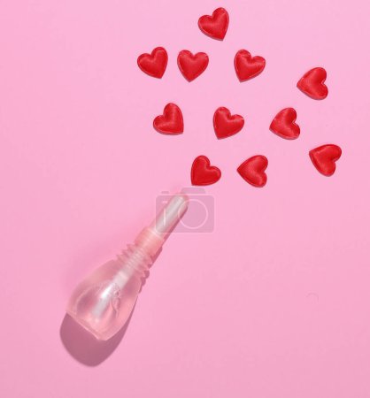 Vaginal enema with hearts on a pink background. Women's health