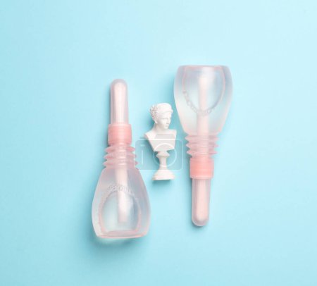 Vaginal enemas with Venus bust on a blue background. Women's health