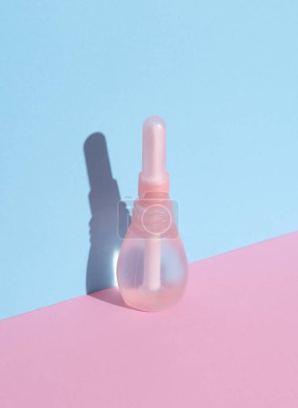 Enema vaginal sobre fondo rosa azulado. Salud de la mujer