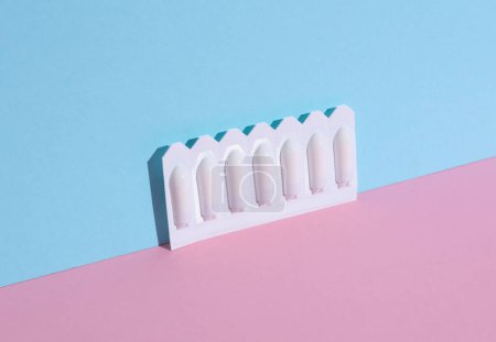 Blisters of vaginal suppositories on a pink blue background. Creative layout