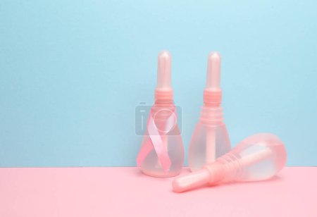 Three Vaginal enemas on blue pink background. Women's health
