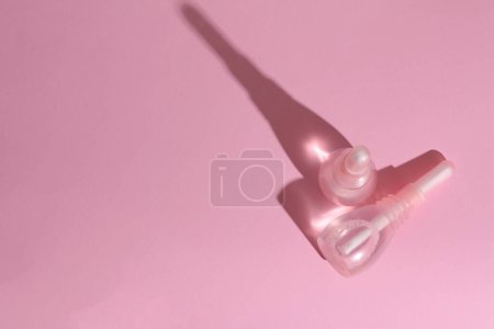 Enemas vaginales sobre fondo rosa. Salud de la mujer. Vista superior con sombra